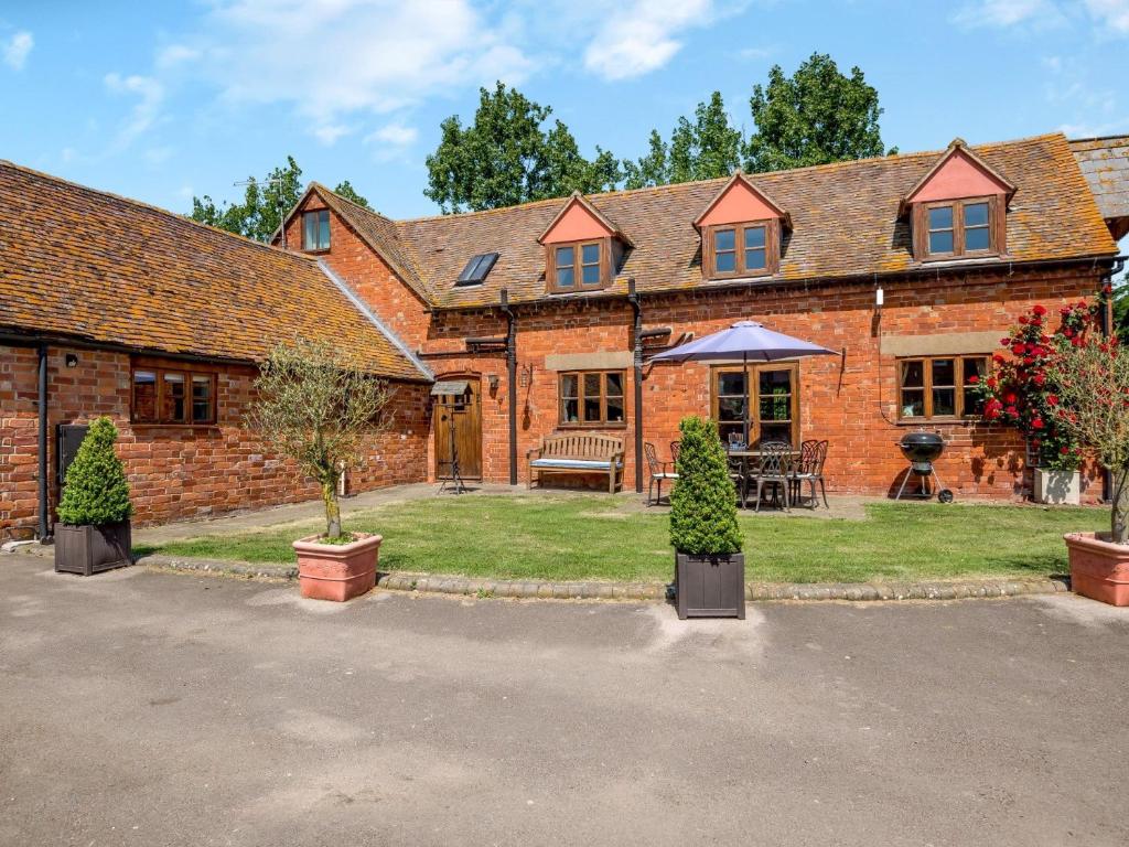 una gran casa de ladrillo con árboles delante de ella en 4 bed in Cheltenham 41216, en Tirley