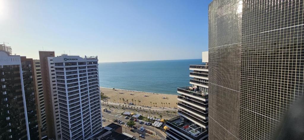 a view of a beach between two tall buildings at 2201 - Vista mar lateral! Apto para 5 pessoas com ar e vaga in Fortaleza