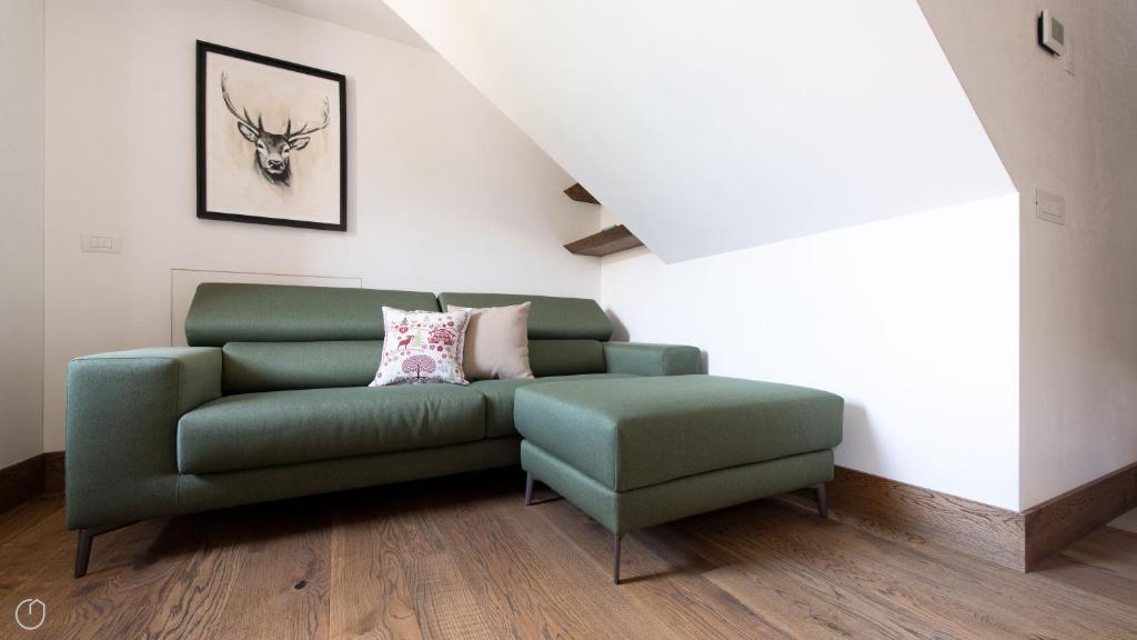 a green couch and a chair in a room at Morcelli 4 - Bajona in Bormio