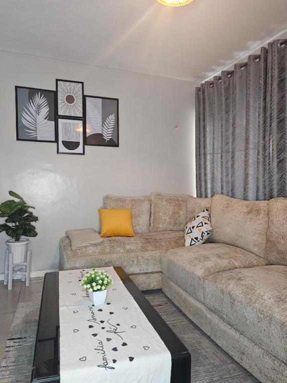 een woonkamer met een bank en een salontafel bij One Bedroom Apartment by Birnes Haven in Ongata Rongai 