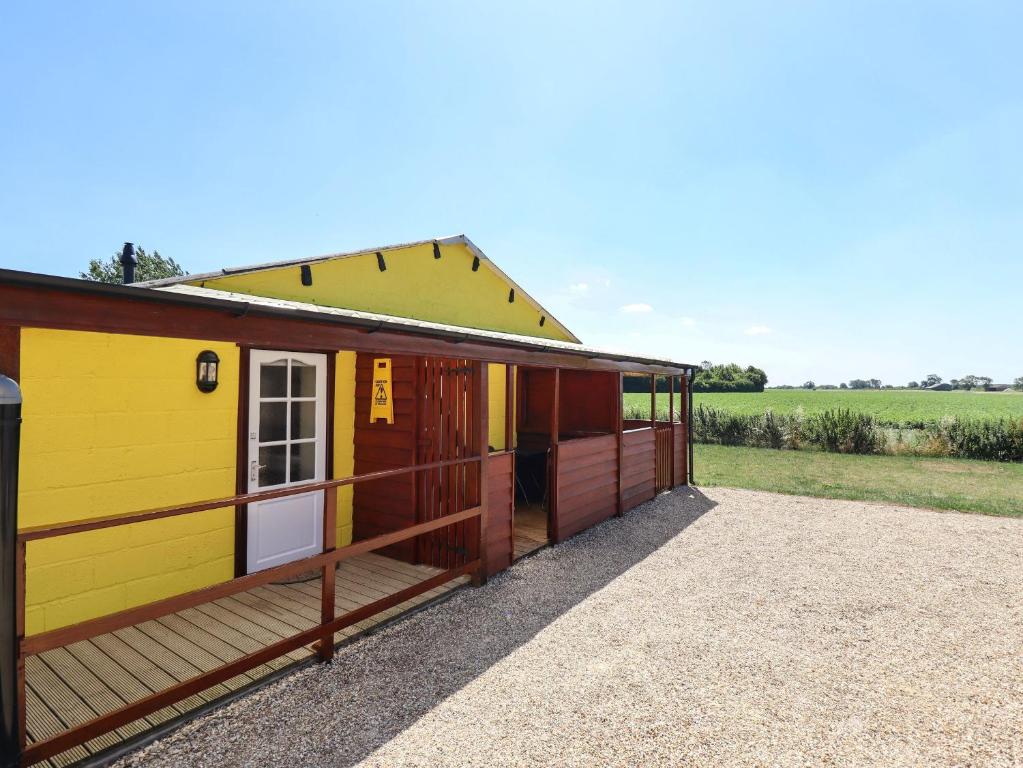 a small yellow and red house with a porch at Dakota in Lincoln