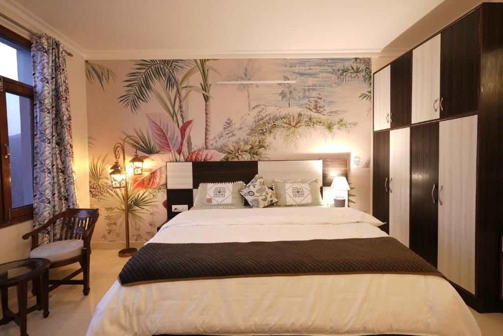 a bedroom with a large bed and a painting on the wall at Wandernest Homes Casa Da Flora in Mashobra