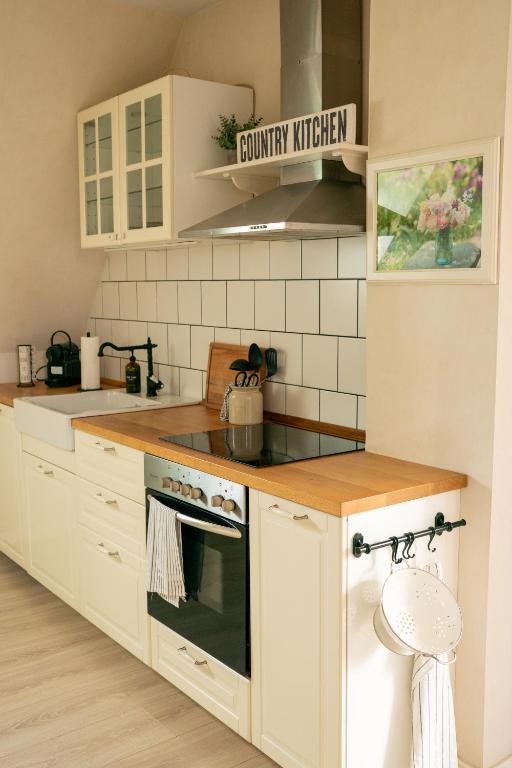 a kitchen with white cabinets and a stove top oven at Ferienwohnung Am Hafen in Bleckede