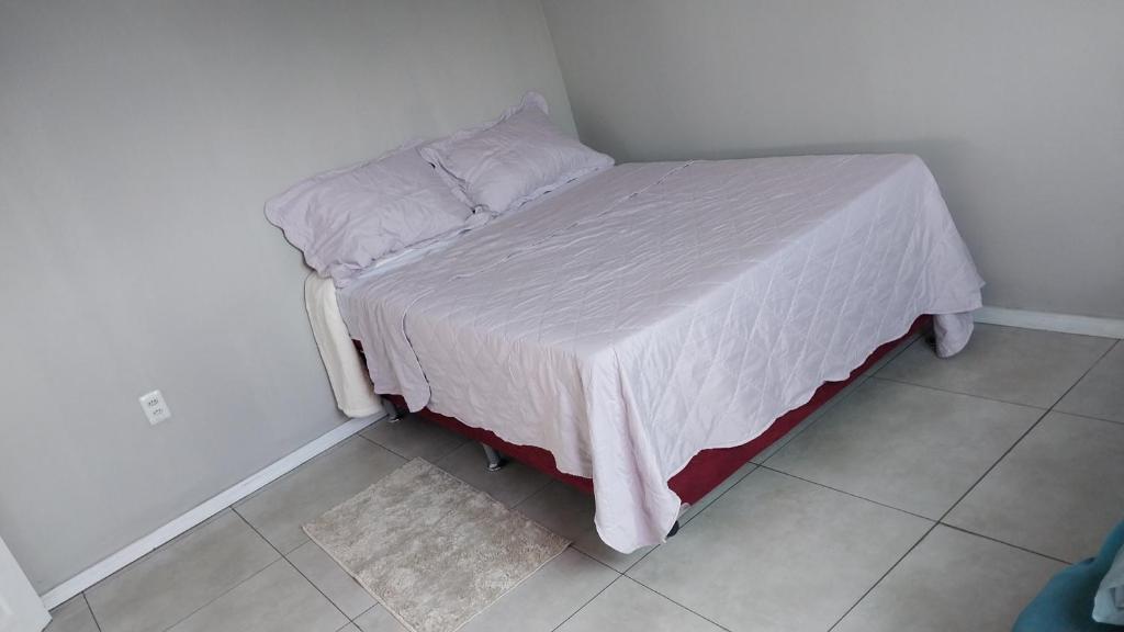 a small bed in a bedroom with a white bedspread at Casa COP 30 in Belém