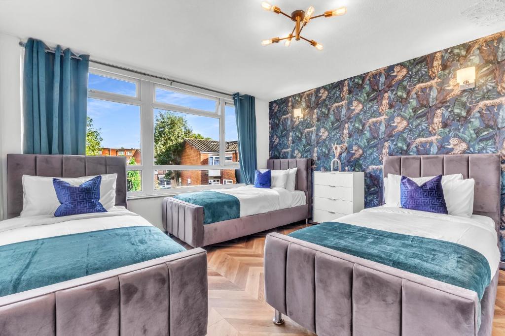 - 2 lits dans une chambre avec une fresque murale dans l'établissement Large 4 Bedroom House - Sleeps 10 - Birmingham City Centre - Perfect for Work, Families, Groups, Business Travellers & Contractors - FREE PARKING - By 02 Academy, Bullring, Newstreet, Selfridges - SMART TVs in all rooms, à Birmingham