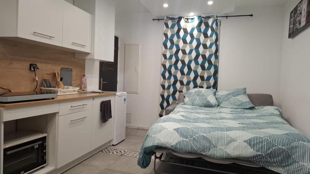 a small kitchen with a bed and a sink at studio proche du marché de Noël de Strasbourg in Schiltigheim