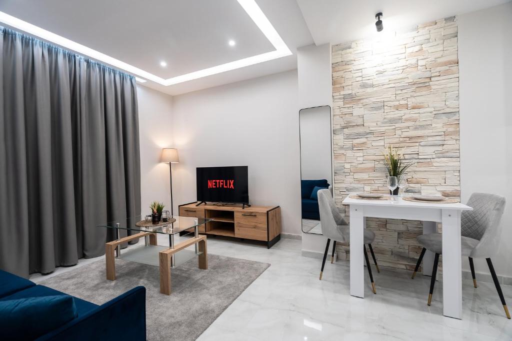 un salon avec un canapé, une table et une télévision dans l'établissement Urban Pulse by #db premium stay apartments, à Thessalonique