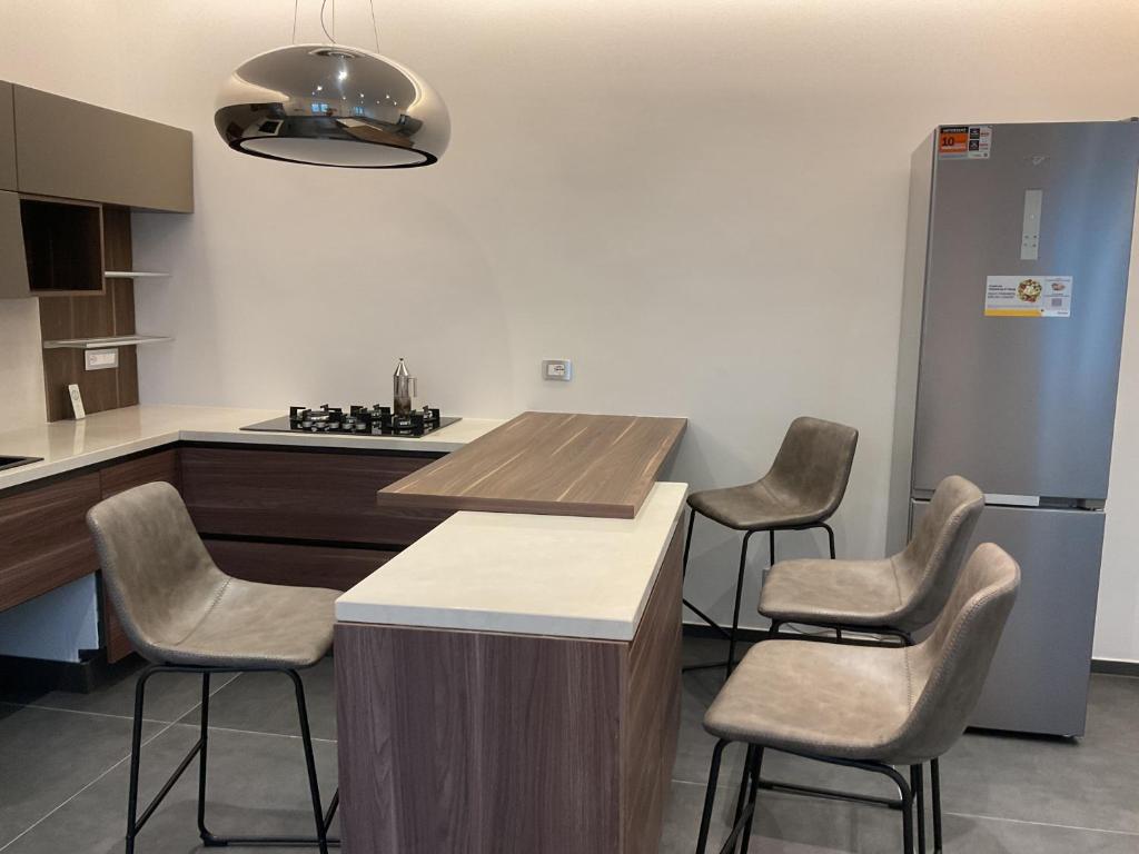 a kitchen with a counter with chairs and a refrigerator at La residenza in Nardò