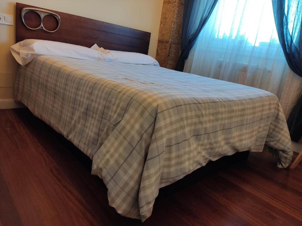 a bedroom with a bed with a checkered blanket at CA Cantábrico a la vista, frescor a tu alcance in Santander