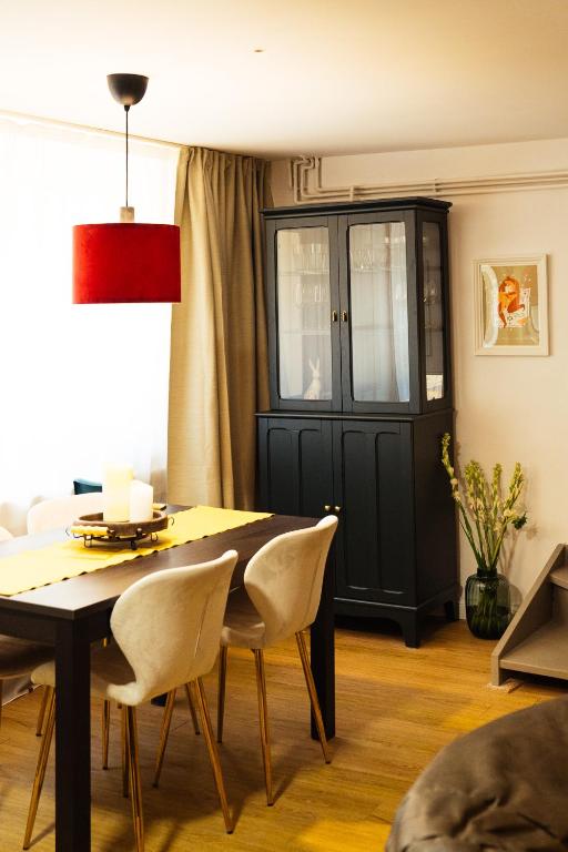 a dining room with a black door and a table and chairs at Cotroceni Accommodations House in Bucharest