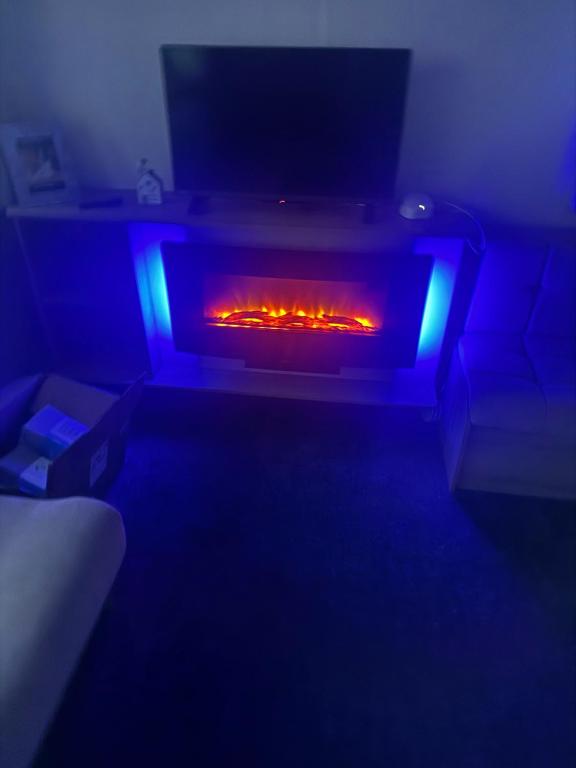 a living room with a fire in a fireplace at Dawbers Retreat in Selsey