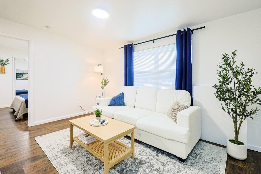 Una sala de estar con un sofá blanco y una mesa. en Chic 1BR Near University, en Maryville