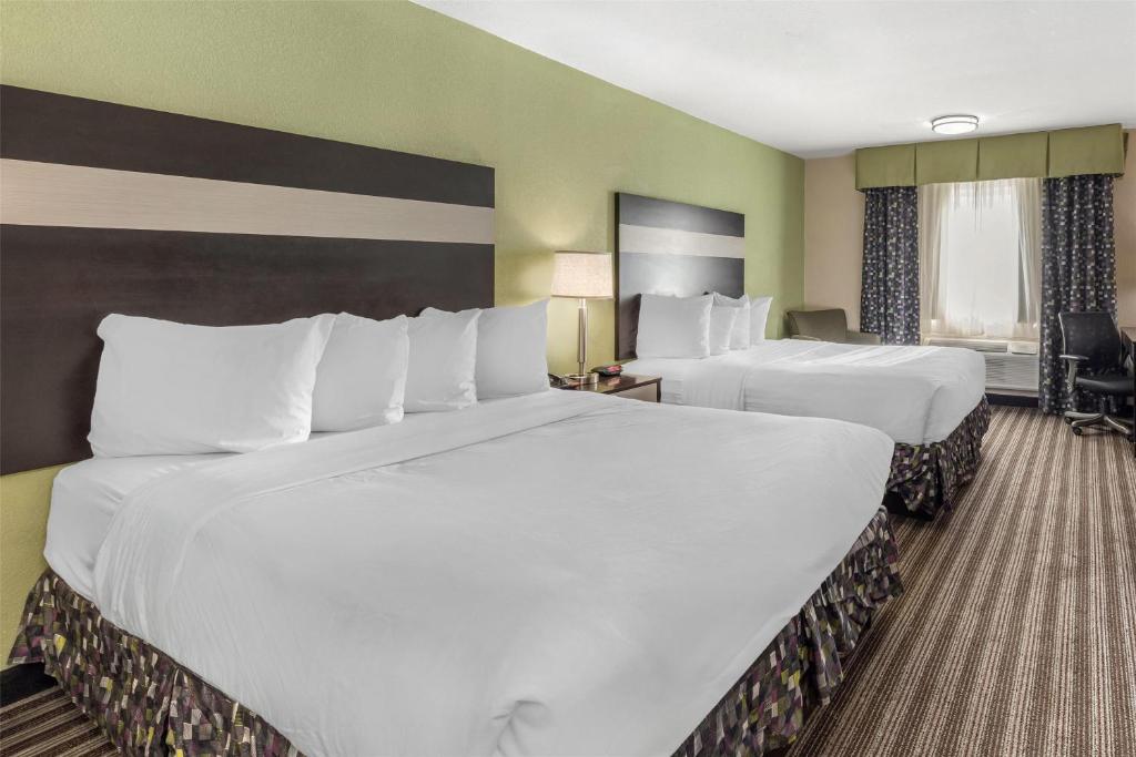 two beds in a hotel room with white sheets at Best Western Borger Inn in Borger