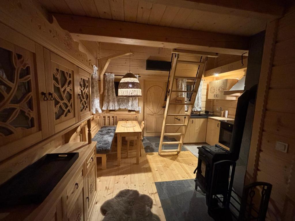 a room with a kitchen and a ladder in a room at Osada na Skale Domek z kominkiem in Istebna