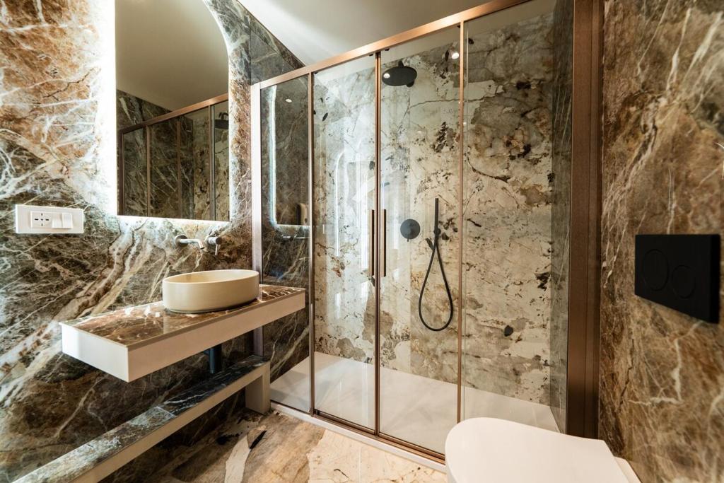 une salle de bain avec un lavabo et une douche dans l'établissement Raffaello Moscova Golden House, à Milan