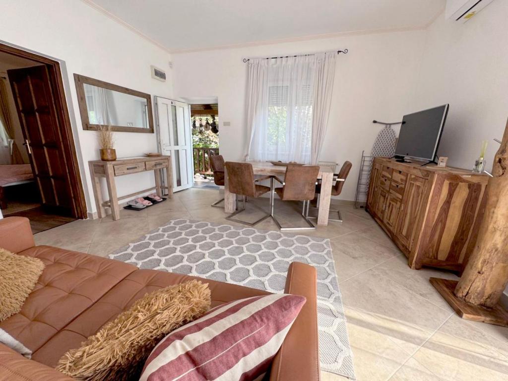 a living room with a couch and a table with a television at Full 2BDR Garden House near to Downtown Metro Free Parking in Budapest