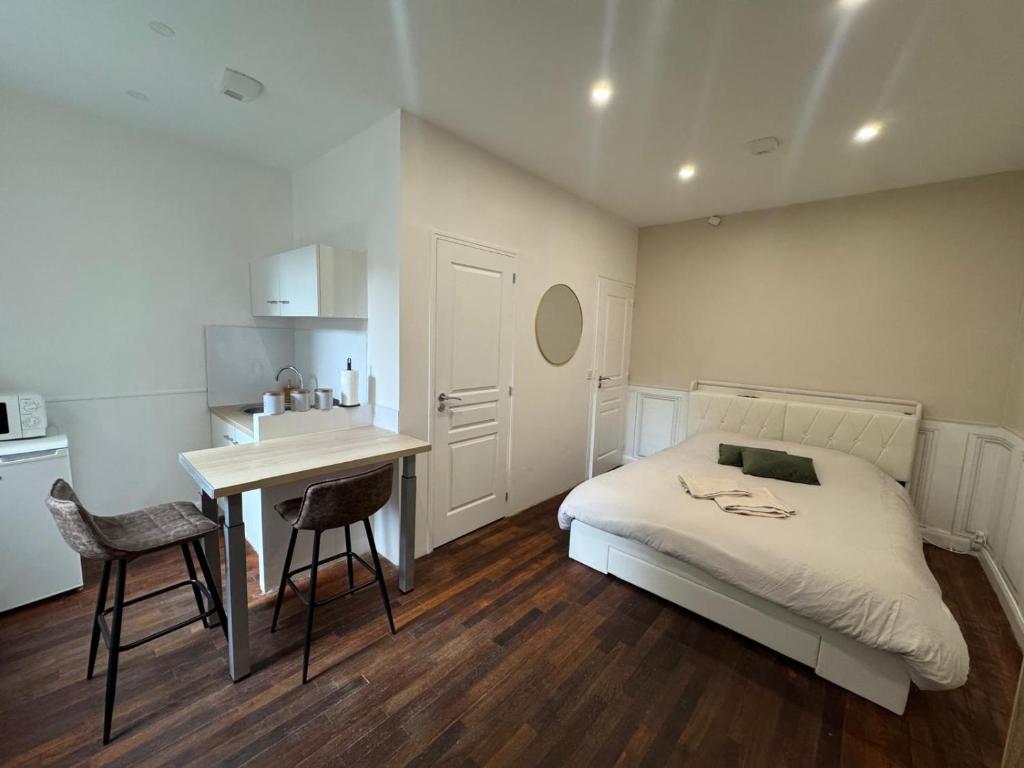a bedroom with a bed and a desk and a kitchen at Le Cottage du Centre in Boulogne-sur-Mer