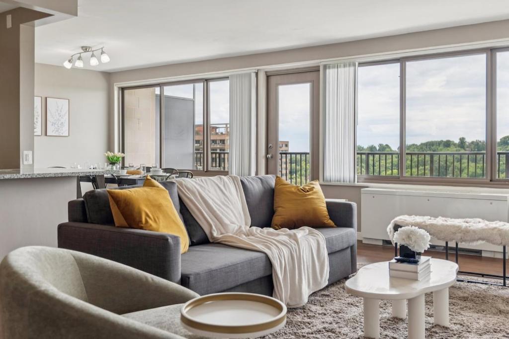 a living room with a gray couch and yellow pillows at Boutique Suite-Sleeps 7-Free Parking-Balcony Views in Arlington