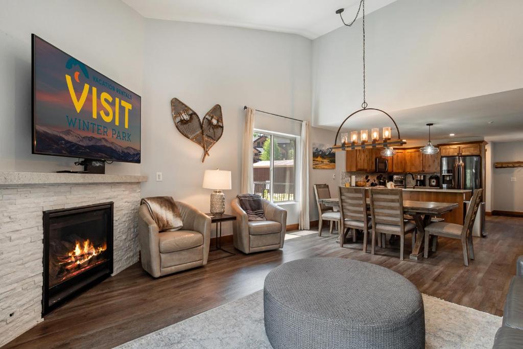 sala de estar con chimenea y comedor en 500 Vasquez Road #5 3BR Townhome in Downtown Winter Park with Deck, en Winter Park