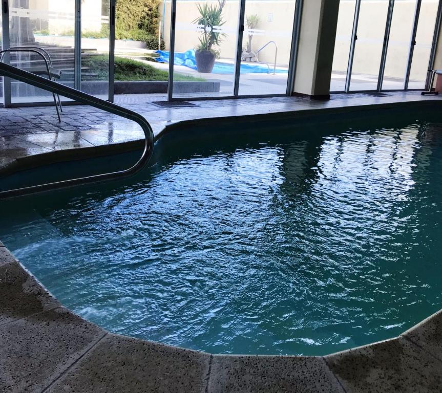 a large swimming pool in a building with a pool at Hotel Esmeralda in Piriápolis