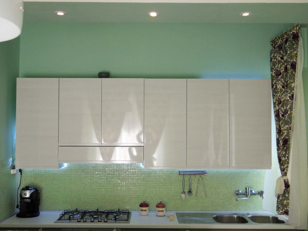 a kitchen with white cabinets and a stove top at Bel Fiore in San Benedetto del Tronto