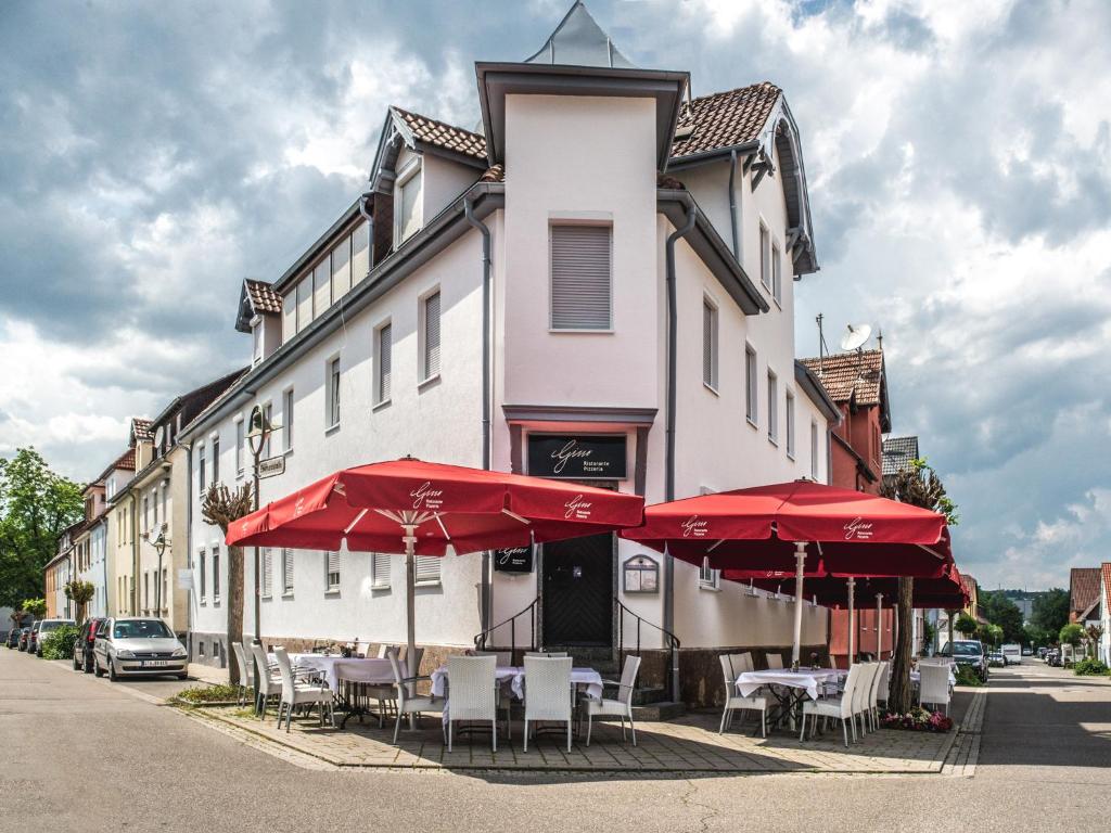 a patio area with tables, chairs and umbrellas at Pension Gino in Nürtingen