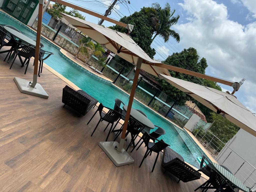 a view of a pool with tables and chairs and umbrellas at HOTEL TERRA NATIVA in Alter do Chao