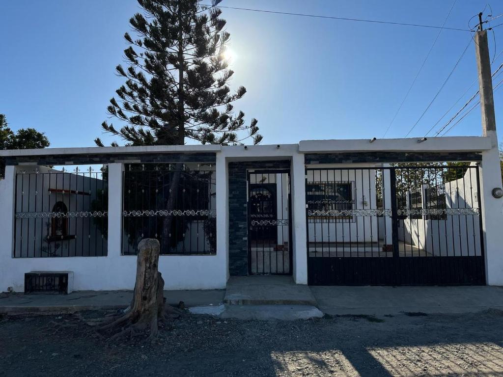 una casa blanca con una puerta y un árbol en Casa Laura, en El Venadillo