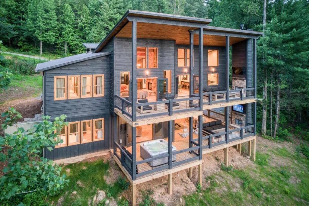 a house in the woods with a lot of windows at Morgan Trail - Stunning Mountain Masterpiece in Epworth