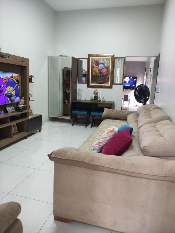a living room with a couch and a television at Casa Fernandes in Rio Verde