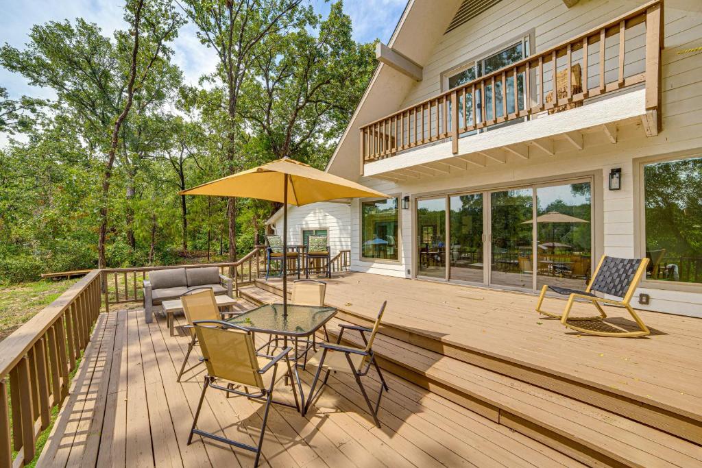 een terras met een tafel en stoelen en een parasol bij Private Dock Waterfront Cedar Creek Lake Home in Eustace