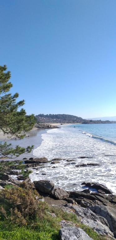 a view of a beach with rocks and the ocean at Casa Machado in Cangas de Morrazo