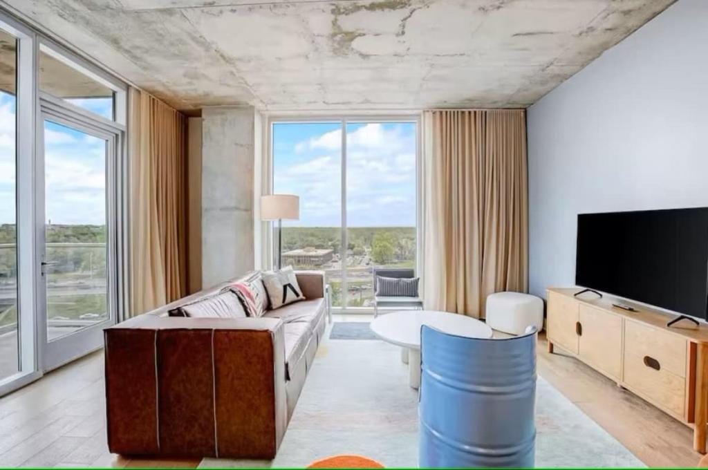 a living room with a couch and a tv at Luxury Oasis - Stunning Condo Unbeatable Location in Austin