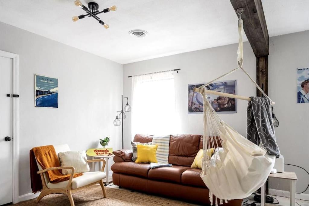 a living room with a couch and a hammock at The PanAm fire pit bbq kid & dog friendly in Pensacola
