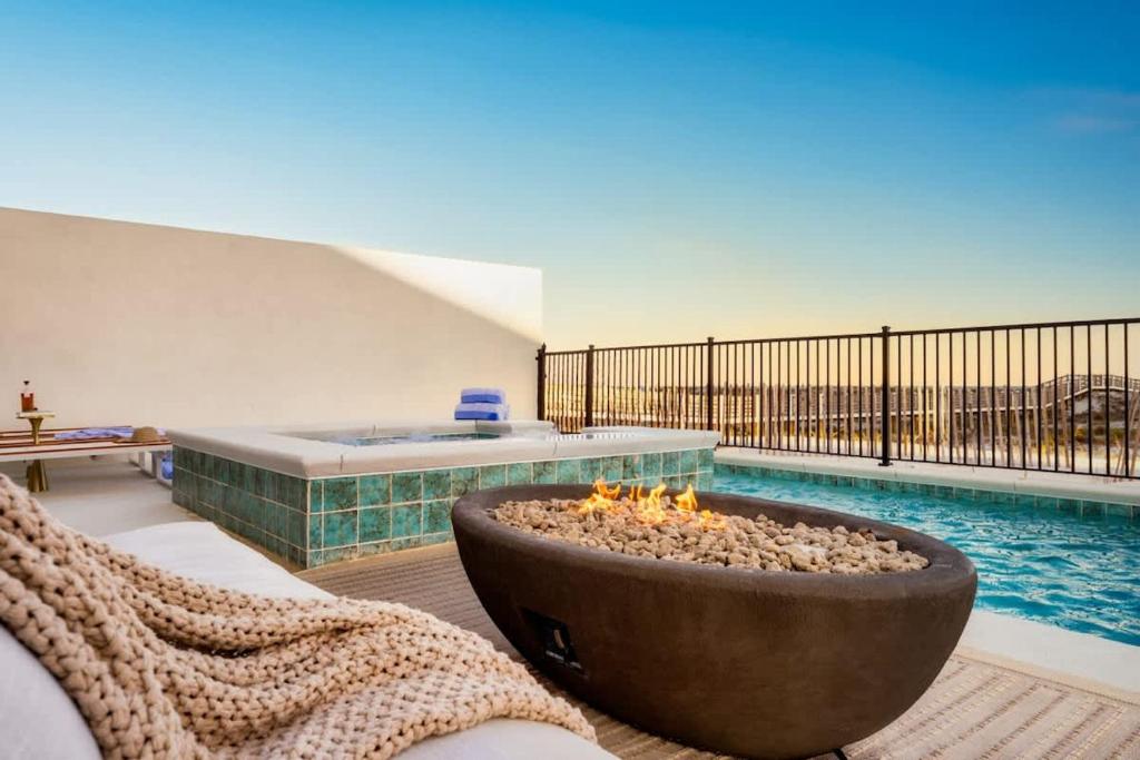 a living room with a fire pit and a swimming pool at Whitecap - Beachfront Gem with Pool & Elevator in Orange Beach