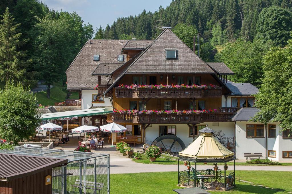 ein großes Gebäude mit Blumen auf der Vorderseite in der Unterkunft Hotel Tannenmühle in Grafenhausen