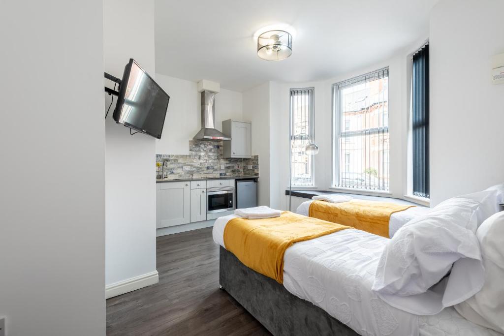 a bedroom with two beds and a kitchen at Comfy Contractor and Holiday Studio - Sleeps 2 in Coventry