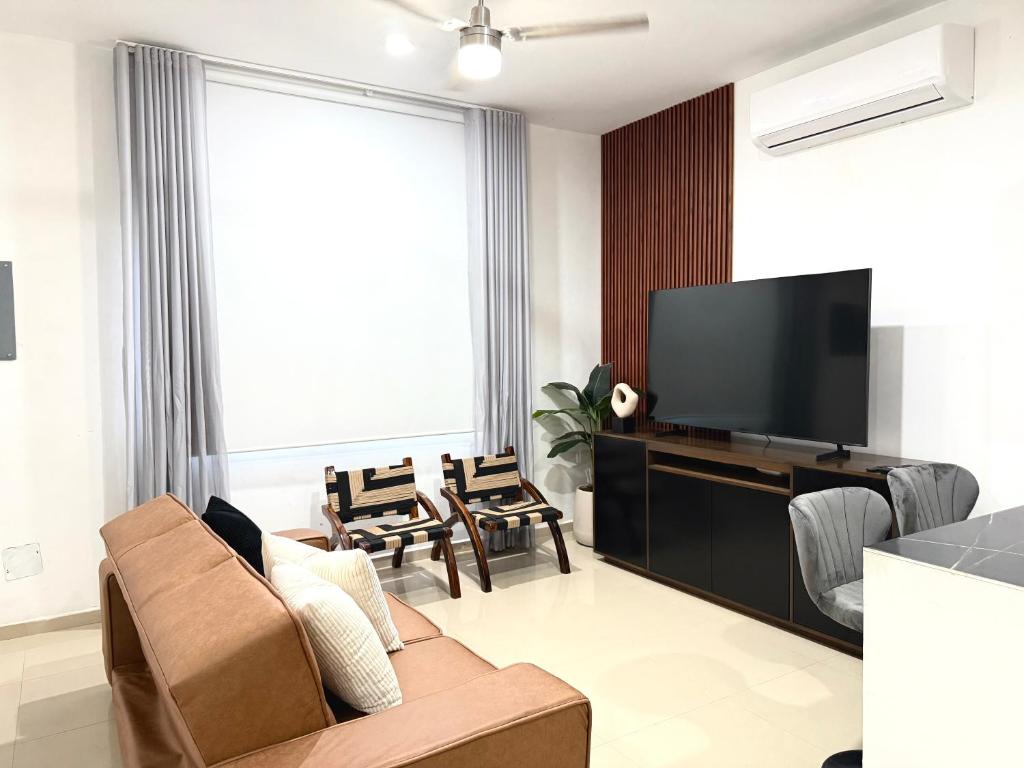 a living room with a couch and a flat screen tv at Encanto de Playa Sur By GEstores in Mazatlán