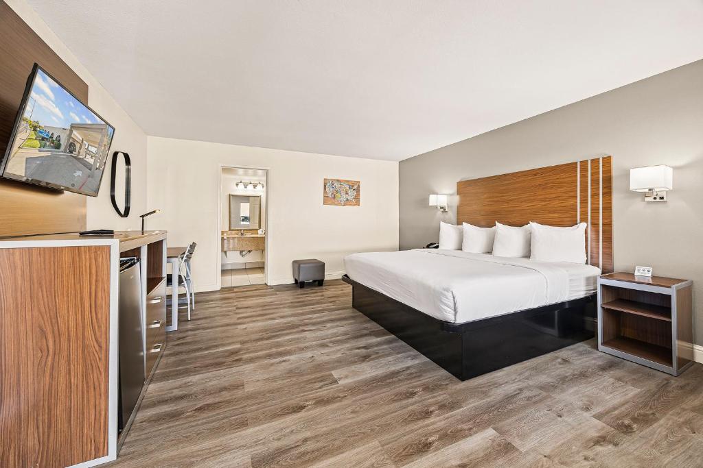 a hotel room with a bed and a flat screen tv at Heritage Inn Express Roseville in Roseville