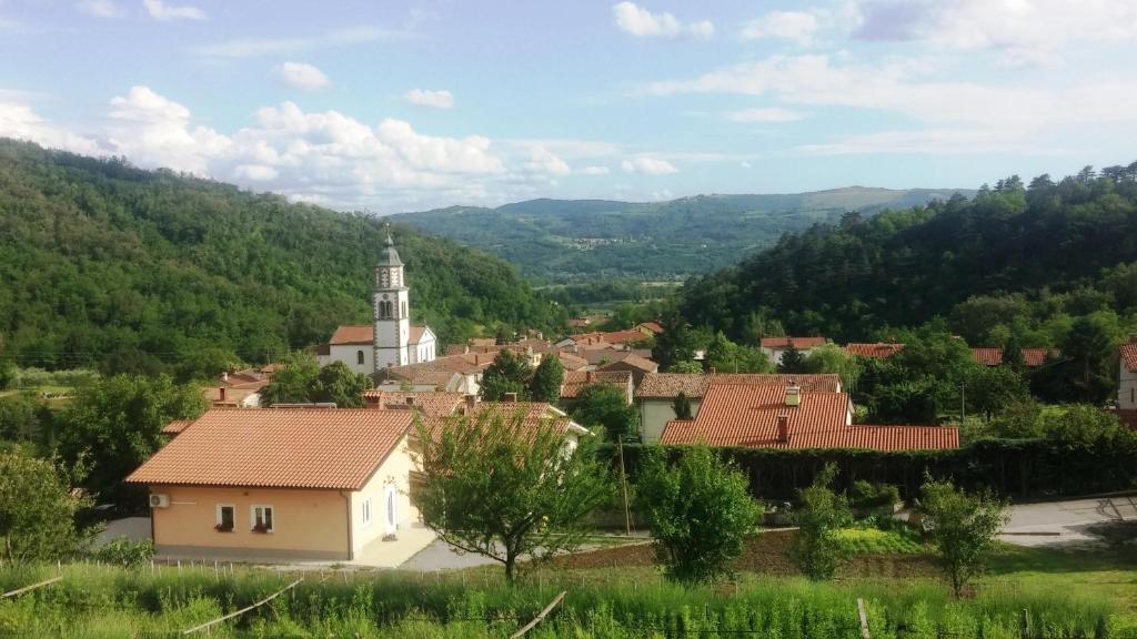 een dorp met een klokkentoren en een kerk bij First Vrtovin Apartment in Črniče