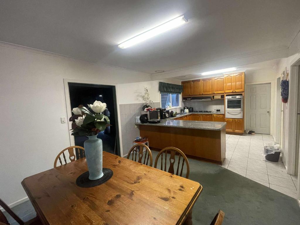 a kitchen with a table with a vase of flowers on it at DoncasterRoom#nearCity&Freeway&Bus#WestfieldShoppingCentre in Doncaster