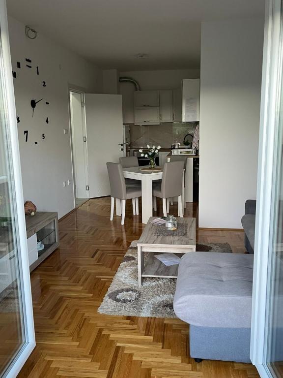 a living room with a table and a kitchen at Apartman N&L in Sombor