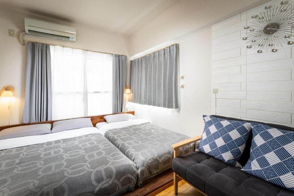 a bedroom with a bed and a couch and a clock at 泉音屋 in Fukuoka