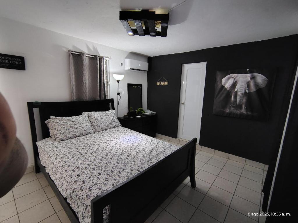 a bedroom with a black and white bed in a room at Duerme Relax 3 in Fajardo