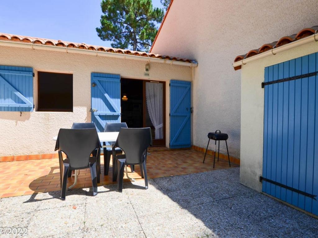 un patio avec une table et des chaises devant une maison dans l'établissement Maison T2 Bis avec Terrasse Privative, proche plage et commerces - LA PALMYRE - FR-1-705-27, à La Palmyre