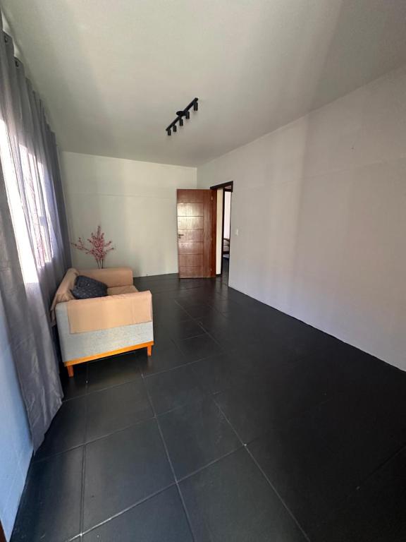 an empty living room with a couch and a window at Pousada Central Araquari in Araquari