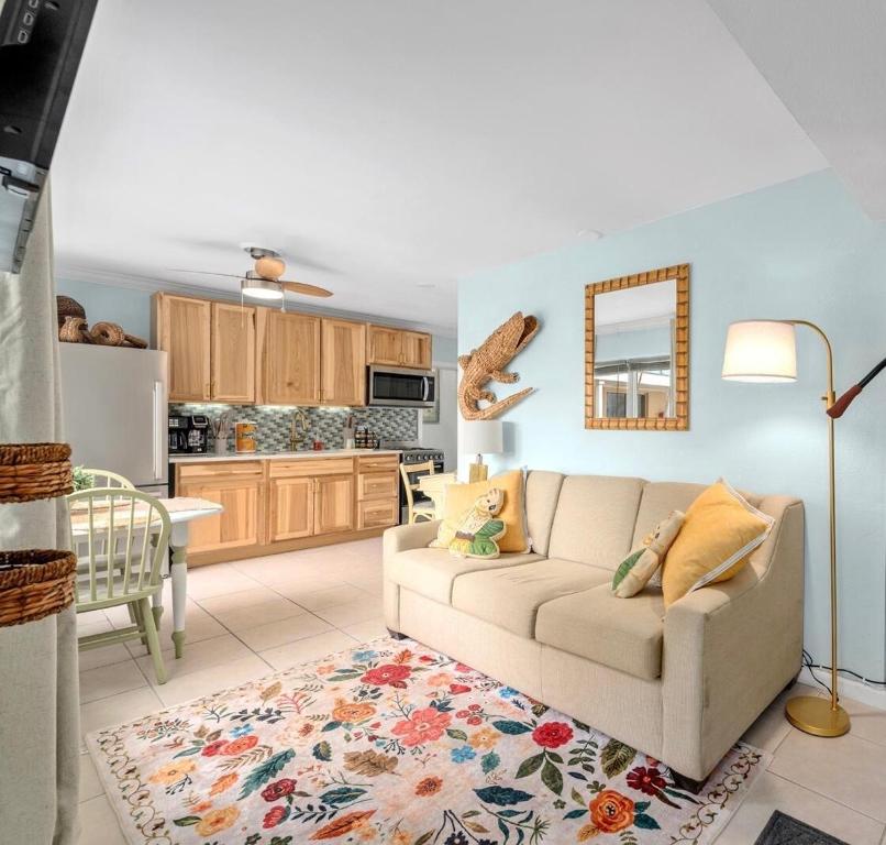 Una sala de estar con un sofá y una cocina. en Cozy Beach Getaway with Bikes included!, en St Pete Beach