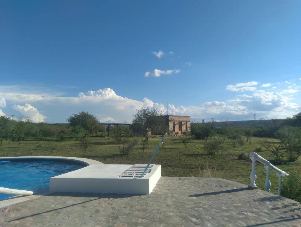 a swimming pool in a field with a building in the background at Casas de Epoca -Serendipia in Charbonier