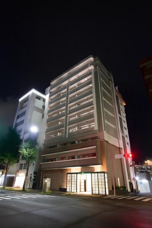 a large building on the corner of a street at night at Hotel ROI 博多 in Fukuoka