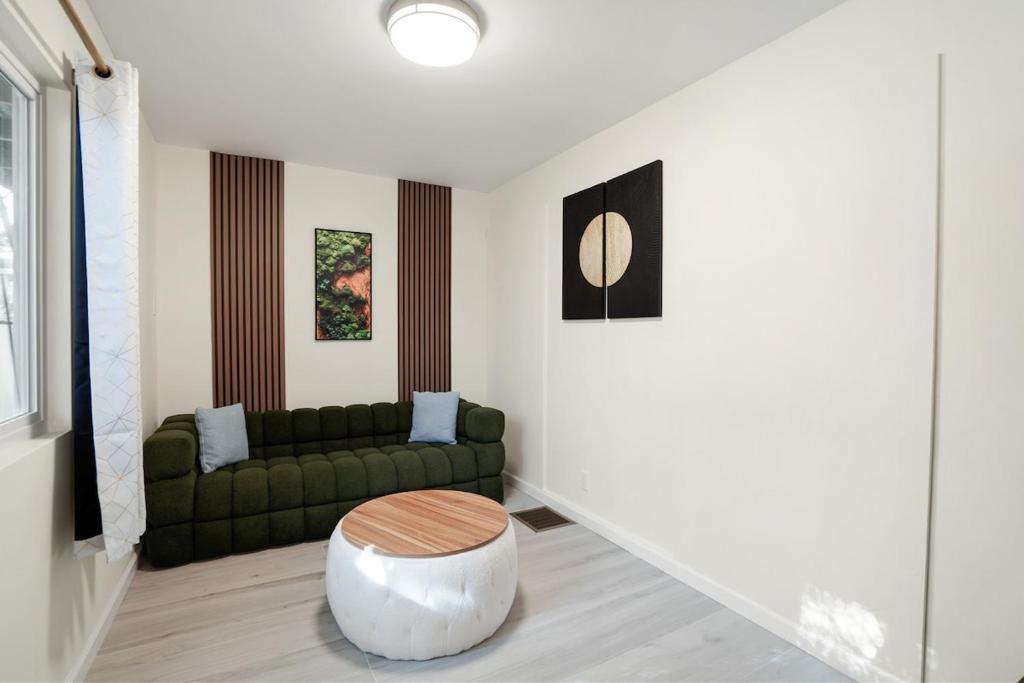 ein Wohnzimmer mit einer grünen Couch und einem Tisch in der Unterkunft Cozy Affordable Private Rooms Newly Renovated near SF Transportation in San Francisco